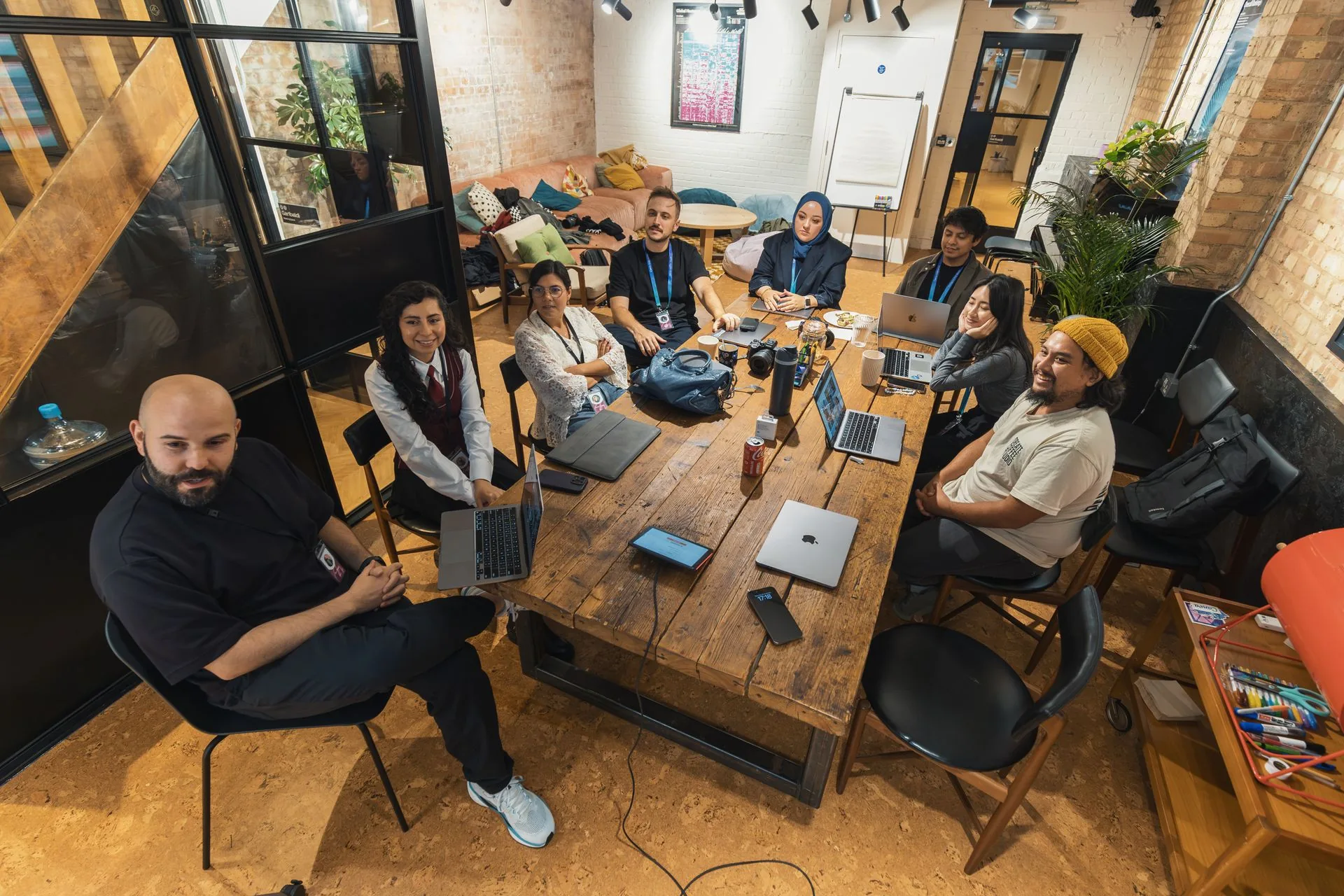 Colleagues gathered around a table with laptops in a modern office